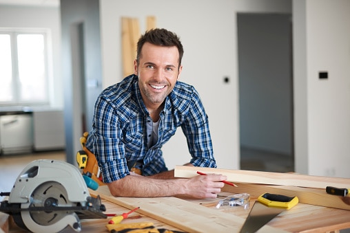 Man leaded over a table full of equipment and contractor tools.